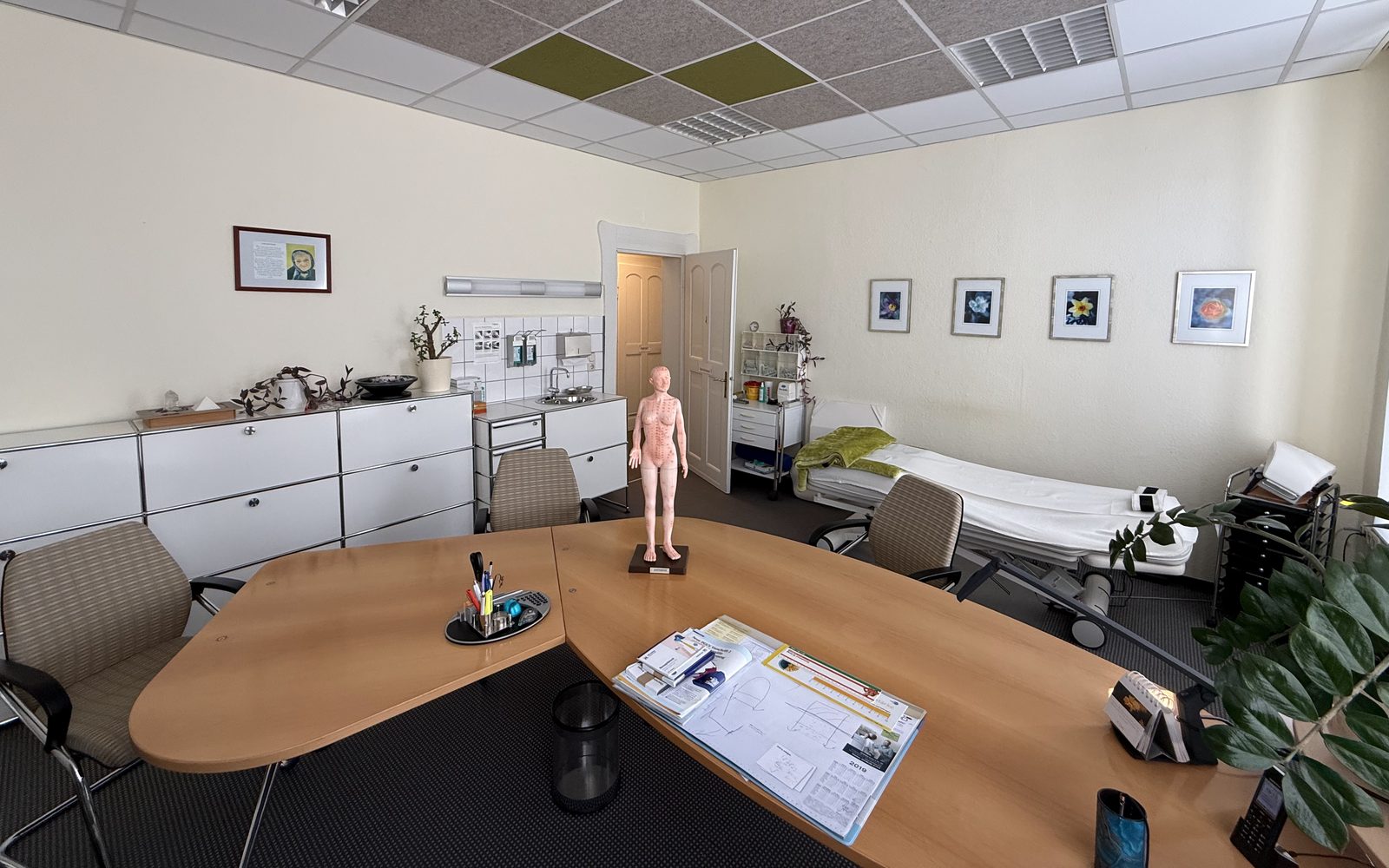 Sprech- und Behandlungszimmer der Praxis in Plauen, mit Besprechungstisch und Behandlungsliege